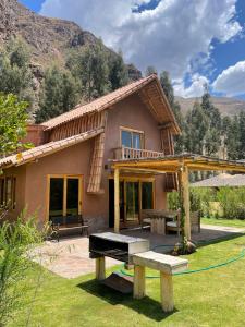 une maison avec un banc devant elle dans l'établissement Casa Mayuwasi Cuzco - Valle Sagrado de los Incas, à Calca