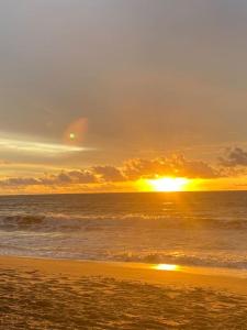 LaGita Carita Villa في كاريتا: غروب الشمس على الشاطئ مع المحيط