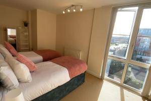 a bedroom with two beds and a large window at Free parking and wi-fi near city centre sleeps 6-8 in Leicester
