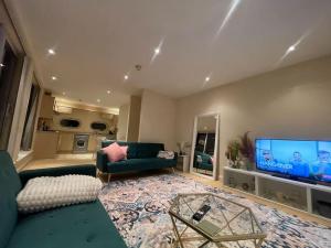 uma sala de estar com um sofá e uma televisão de ecrã grande em Free parking and wi-fi near city centre sleeps 6-8 em Leicester