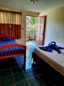 1 dormitorio con 2 camas y puerta a un balcón en Habitación Privada - Apartamentos Morpho CR, en Quepos
