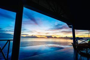 a view of the ocean at sunset from a house at Villa Club Tropicana Carana with private infinity pool in Machabee