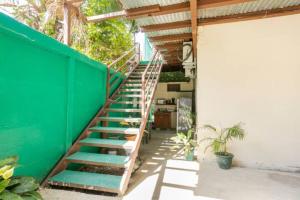 una escalera con una pared verde junto a un edificio en Habitación Privada - Apartamentos Morpho CR, en Quepos
