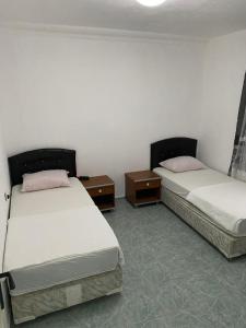 two beds in a room with two nightstands and sidx sidx sidx at *** DiDiM BEYAZ *** in Didim