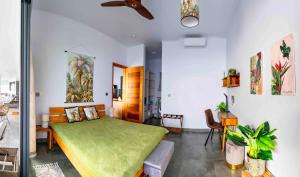 a bedroom with a green bed in a room at Villa Club Tropicana Carana with private infinity pool in Machabee
