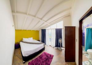 um quarto com uma cama e uma parede amarela em Altos Agua Blanca em Tauramena