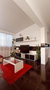 sala de estar con sofá y alfombra roja en Kanela Guest house en Machico