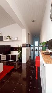 cocina con taburete rojo en una habitación en Kanela Guest house, en Machico