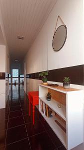 Kanela Guest house في ماتشيكو: حمام به كرسي احمر ومرآة على الحائط