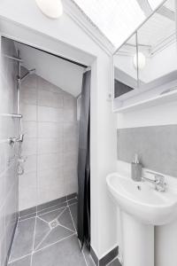 a white bathroom with a sink and a shower at Maison de ville triplex proche CDG in Sevran +24 photos