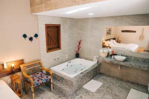 a large bathroom with a tub and a bed at Adega Cipó Pousada Serra do Cipó in Serra do Cipo