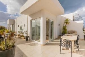 a white house with a patio with a table and chairs at Stunning - Seaview Penthouse 3-Bed + Parking in Sliema