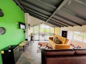 uma sala de estar com paredes verdes e um sofá em Altos Agua Blanca em Tauramena