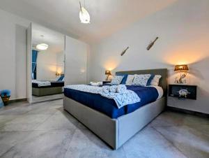 a bedroom with a large bed and a mirror at I colori della Sicilia in Cinisi