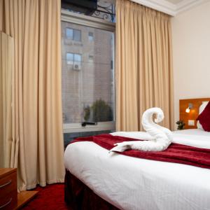 安曼的住宿－Sama Paris Plaza Hotel，酒店客房设有两张床,上面有天鹅