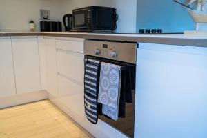 una cucina con piano cottura e asciugamani appesi di 30% Off Monthly Stay/2Bed House - Sittingbourne a Kent