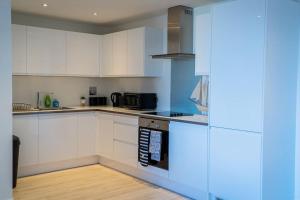 una cucina con armadi bianchi e piano cottura di 30% Off Monthly Stay/2Bed House - Sittingbourne a Kent