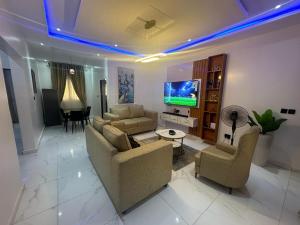 a living room with two couches and a tv at Bae apartment in Oba Ile