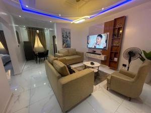 Il comprend un salon avec des canapés et une télévision à écran plat. dans l'établissement Bae apartment, à Oba Ile