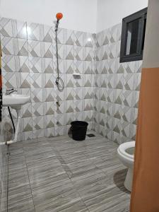 ein Bad mit einem WC und einem Waschbecken in der Unterkunft Hotel Eyram in Palimé
