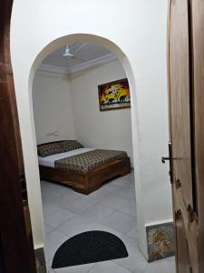 ein Schlafzimmer mit einem Bett in einem Zimmer mit einem Torbogen in der Unterkunft Hotel Eyram in Palimé