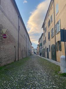 an empty street in an alley between buildings at Teatro Inn - Timeless Charm in Correggio