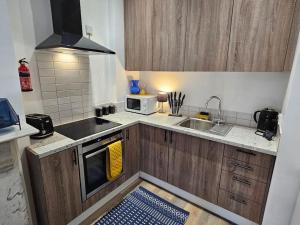 a small kitchen with a sink and a microwave at Coolinge Apartment in Kent