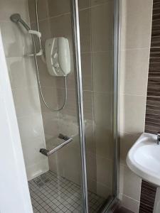 a shower with a glass door next to a sink at Woodquay Mews in Galway