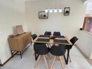 a dining room with a wooden table and chairs at Green Apartment in Tavira Garden in Tavira