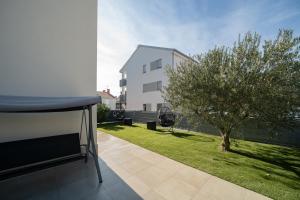 uma varanda com uma árvore e um edifício branco em A&V Residence em Novigrad Istria