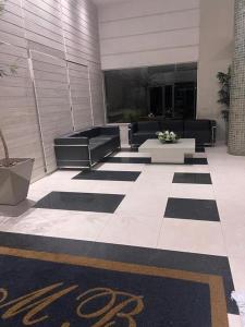 a lobby of a building with black and white furniture at Alugo 1 Suite 210 no Mont Blanc in Nova Iguaçu