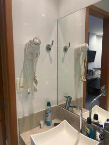 a bathroom sink with a mirror and a hair dryer at Alugo 1 Suite 210 no Mont Blanc in Nova Iguaçu