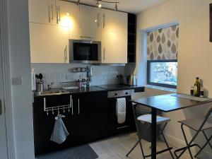 高威的住宿－Woodquay Mews，厨房配有白色橱柜和黑色台面