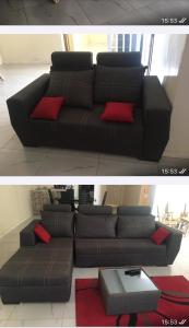 sala de estar con sofá negro y almohadas rojas en Maison FULANI, en Toubab Dialaw