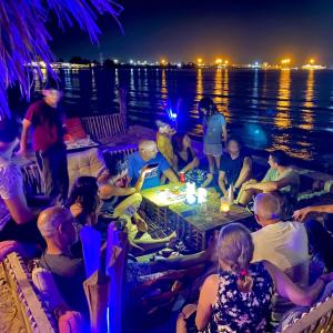 grupa ludzi siedzących na łodzi w nocy w obiekcie Sea View -SunnyDahab Resort w mieście Dahab