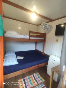 a small bedroom with a blue bed in a boat at Pousada Morada das Flores in Ilha do Mel
