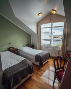 um quarto com 2 camas e uma grande janela em Sel - Hótel Mývatn em Myvatn