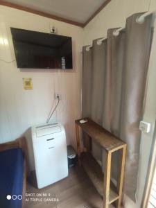 a room with a desk and a television and a sewing machine at Pousada Morada das Flores in Ilha do Mel