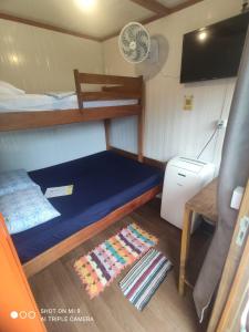 a small room with a bunk bed and a table at Pousada Morada das Flores in Ilha do Mel