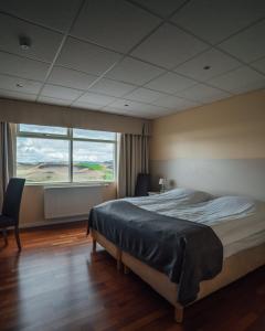 1 dormitorio con cama grande y ventana grande en Sel - Hótel Mývatn, en Myvatn
