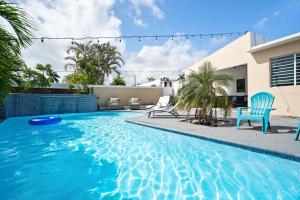 a swimming pool with a blue chair and a house at 4 bedroom family reserve with pool home in Dorado