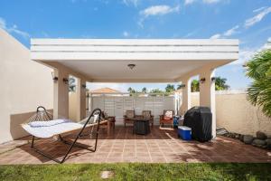 un patio con una pérgola blanca y un columpio en 4 bedroom family reserve with pool home, en Dorado