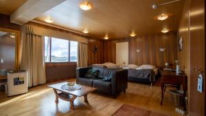 Sel - Hótel Mývatn في ميفاتن: غرفة معيشة مع أريكة وسرير