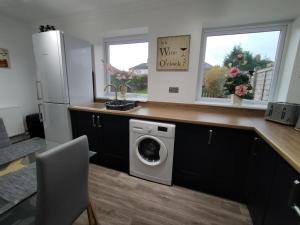 a kitchen with a washer and dryer on a counter at Polaris House - sleeps 6, driveway, garden in Crewe