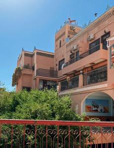 a large pink building with a red balcony at Kasbah La Famille Berbère in Boumalne