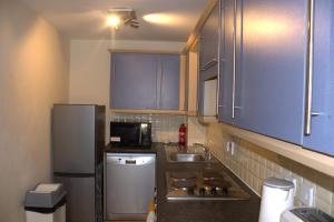 a small kitchen with a sink and a refrigerator at Spacious 2BR flat in Central London near Elephant and Castle station in London