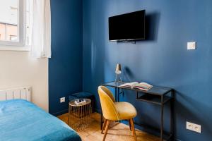 1 dormitorio con pared azul, cama y escritorio en Studios Part-Dieu Gare - HomaLyon en Lyon