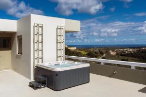 a hot tub on the balcony of a house at Rizes Villa with Jazuzzi & Heated Pool in Agia Triada