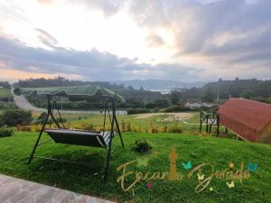 a swing in a grassy field with a view at Encanto Dorado in Guatavita