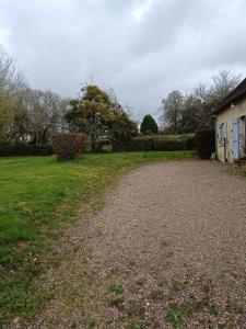 eine Schotterstraße, die zu einem Haus in einem Hof führt in der Unterkunft La petite maison en Puisaye in Dampierre-sous-Bouhy